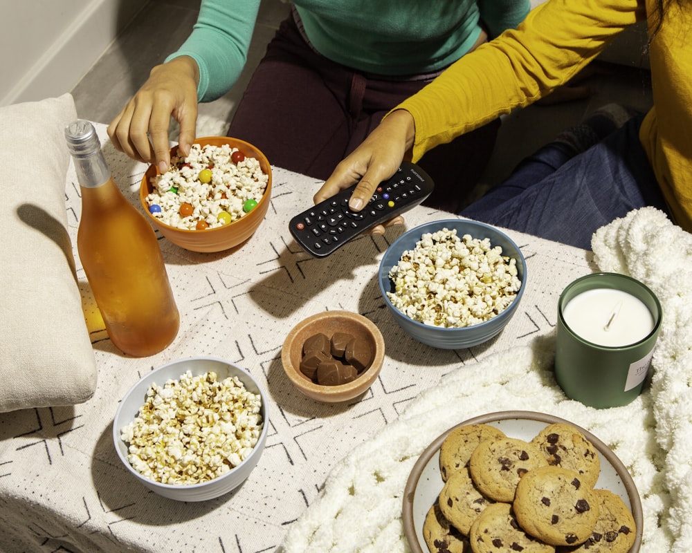 a table topped with bowls of food and a remote control
