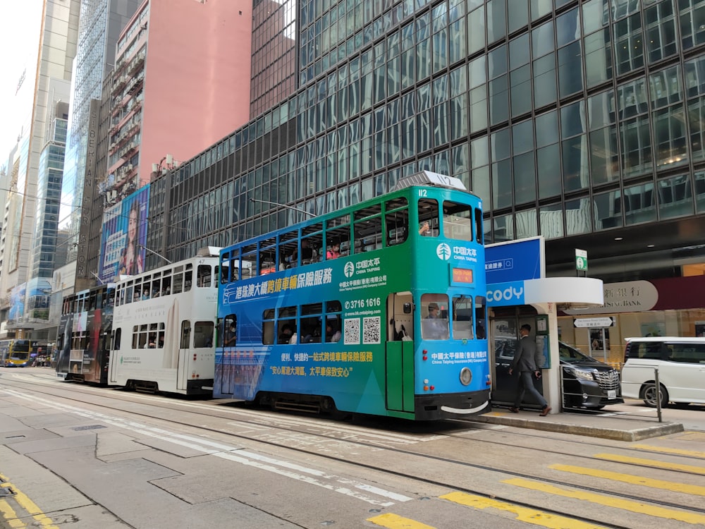 a blue and white double decker bus on a city street