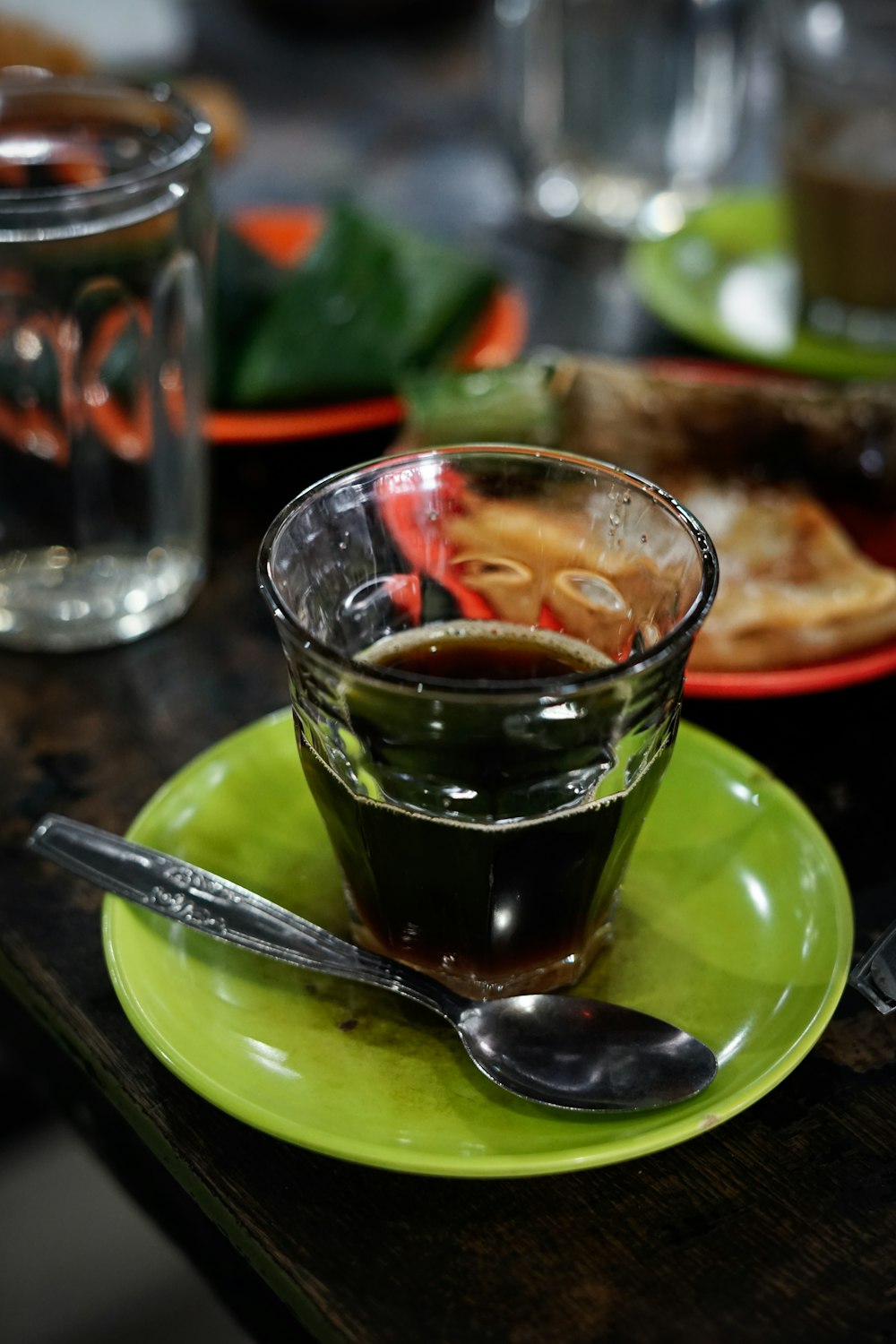 a green plate topped with a cup of liquid