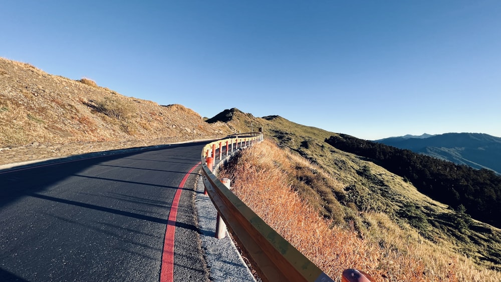 a person taking a picture of a mountain road