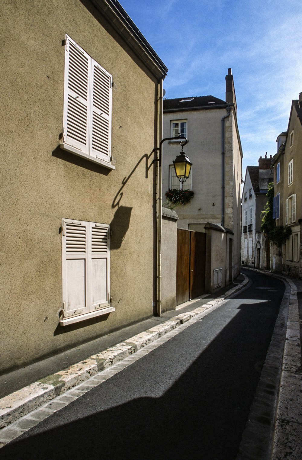 a narrow street with a lamp post and windows