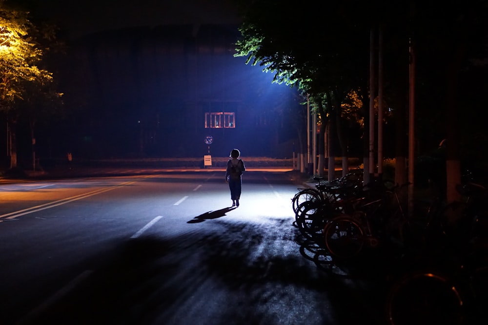 a person walking down a street at night