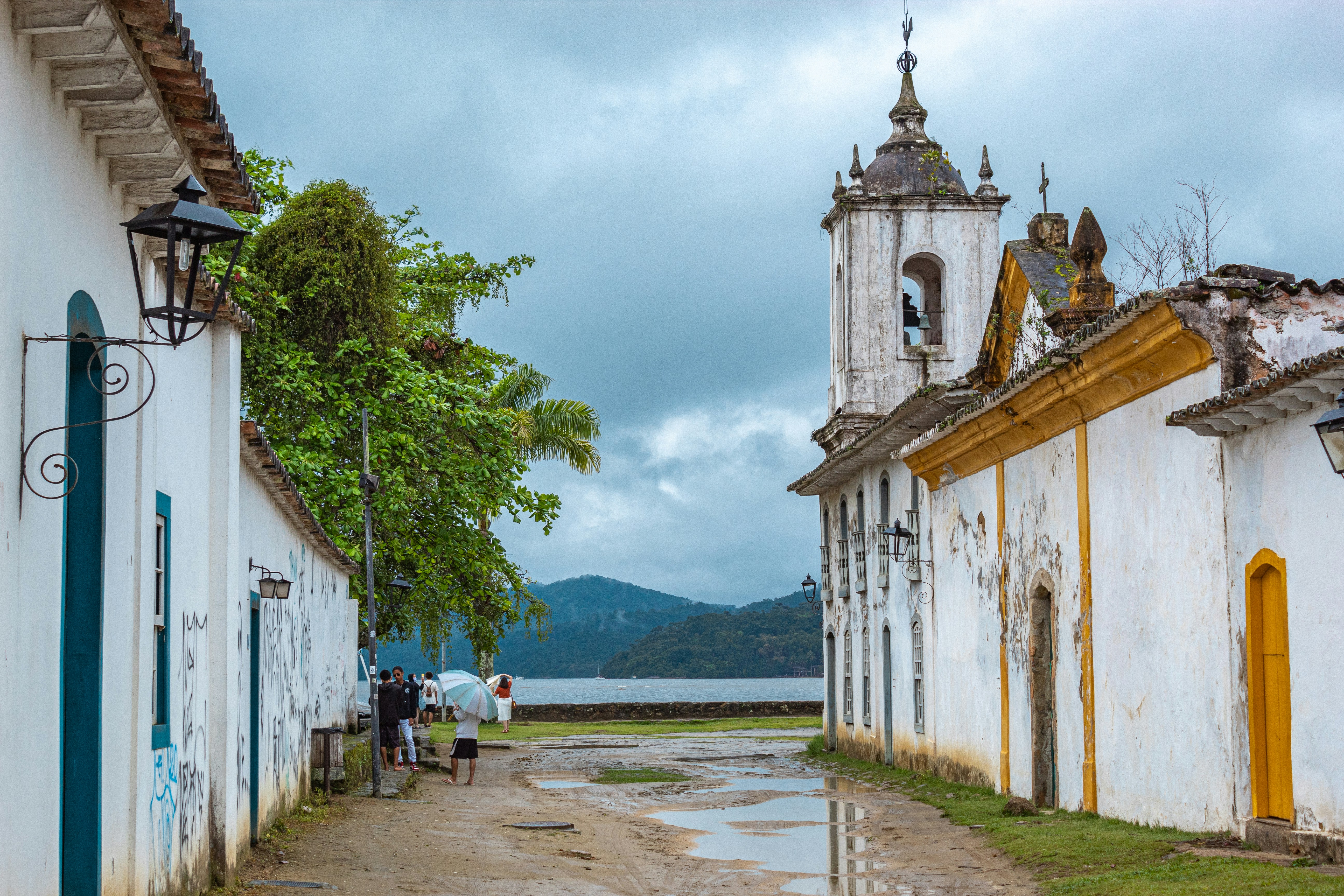 a group of people walking down a street next to a church