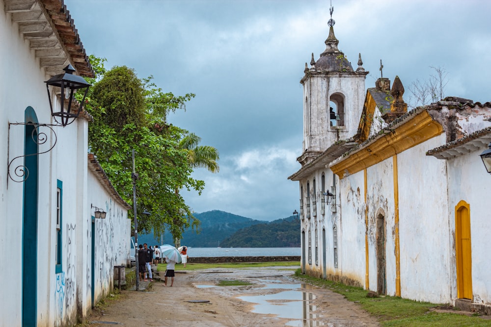 a group of people walking down a street next to a church