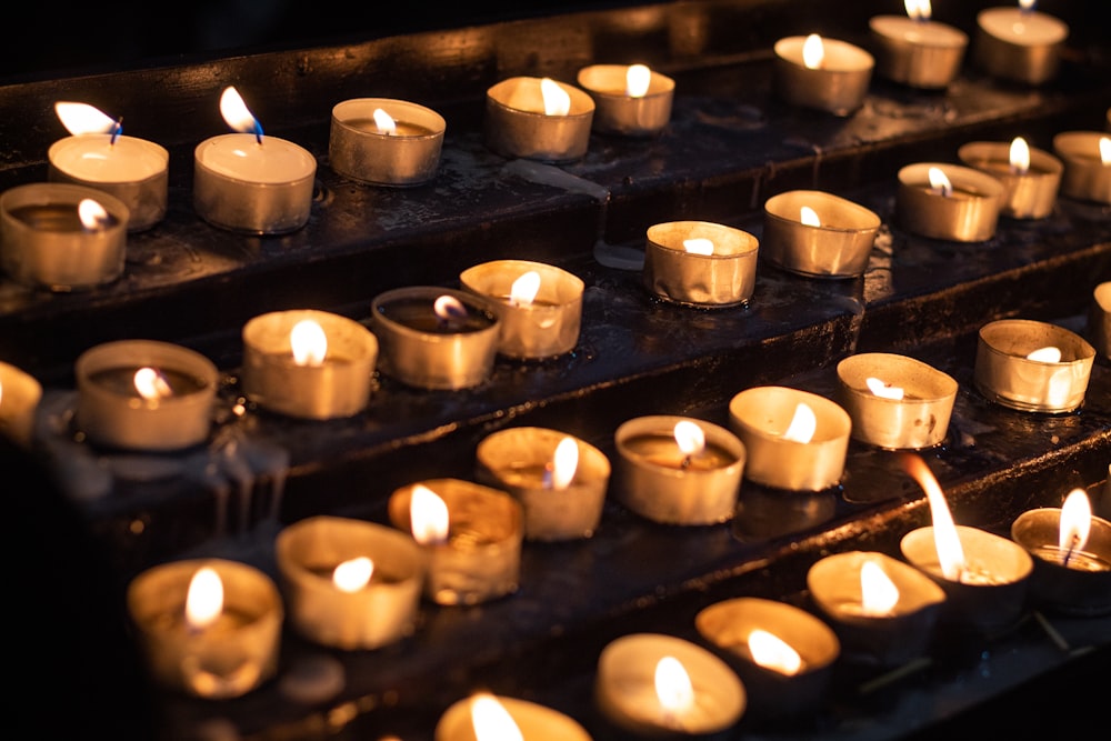 a bunch of lit candles sitting on a shelf