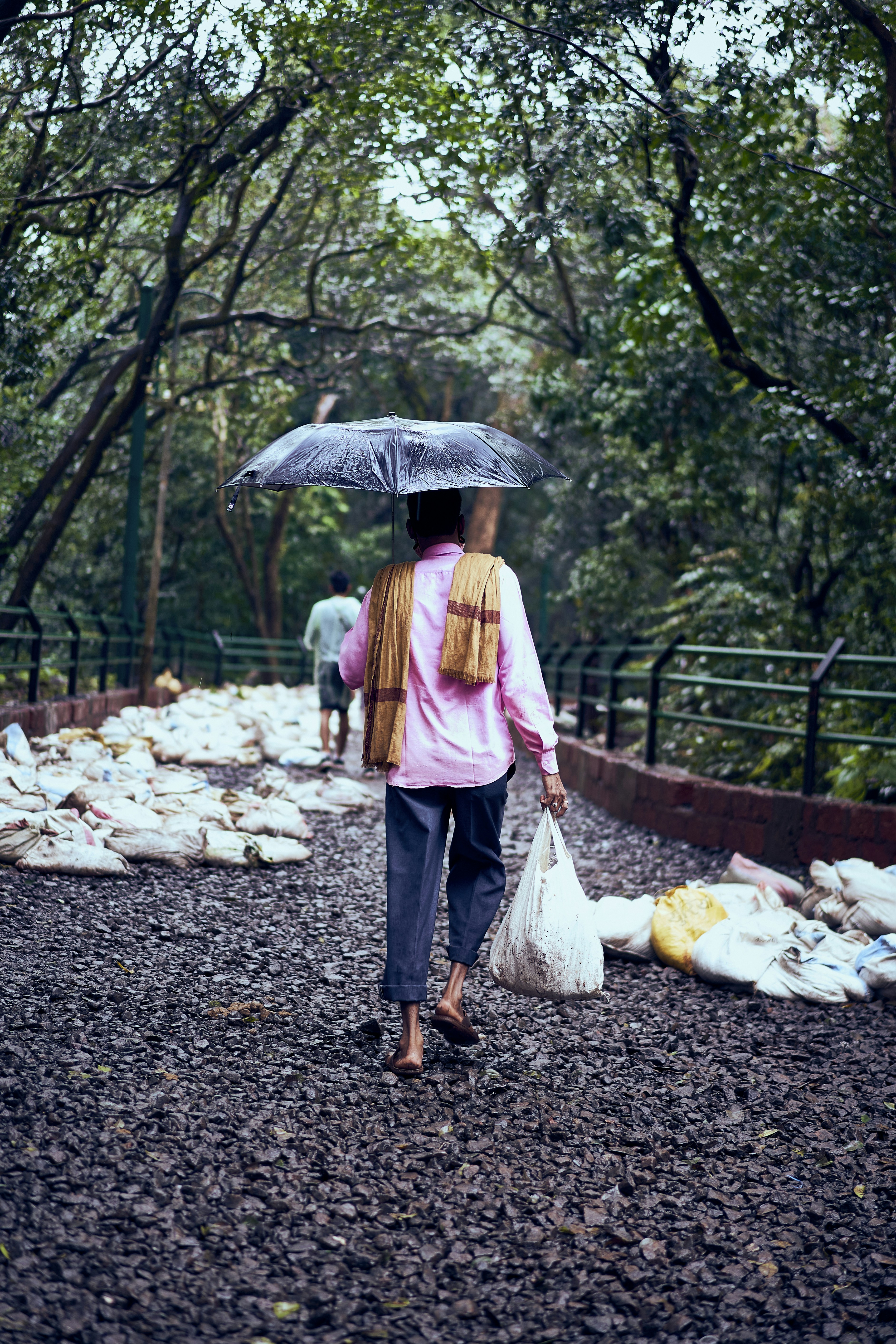 a woman walking down a path holding an umbrella