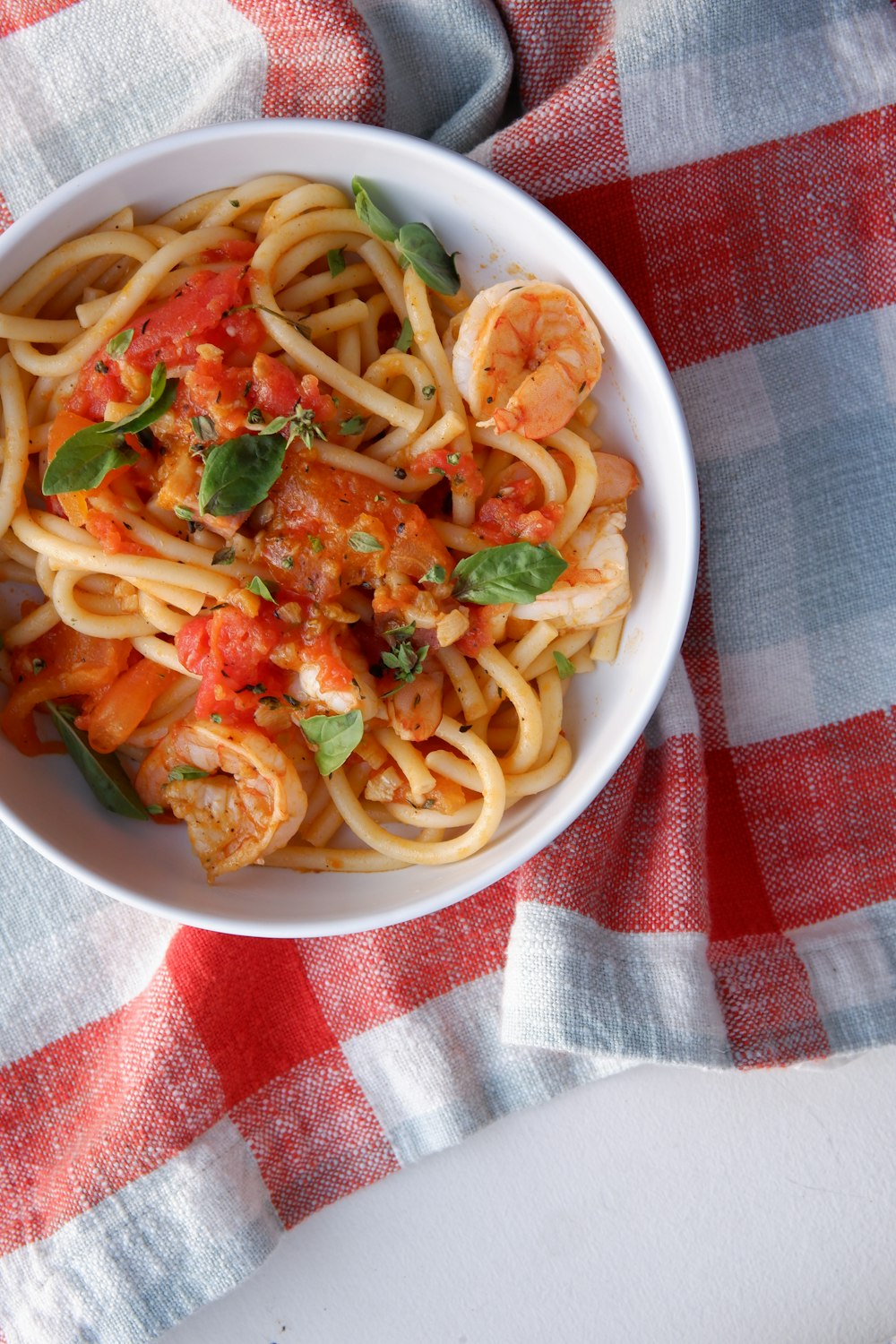 a bowl of pasta with shrimp and tomato sauce