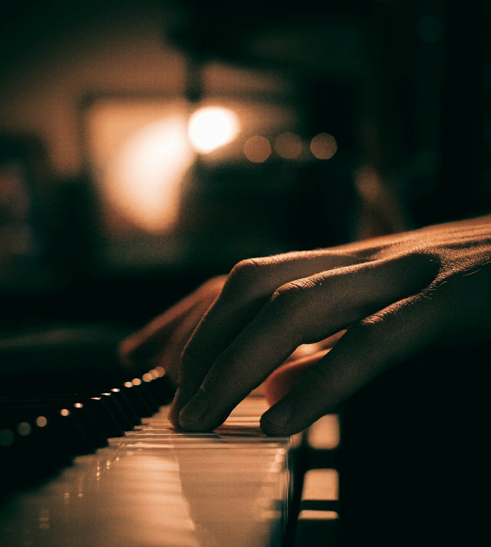 a close up of a person's hand on a piano