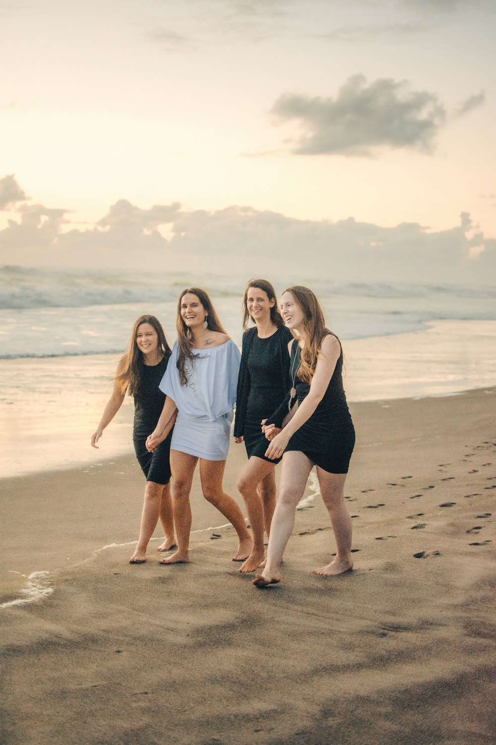 a group of women standing on top of a sandy beach