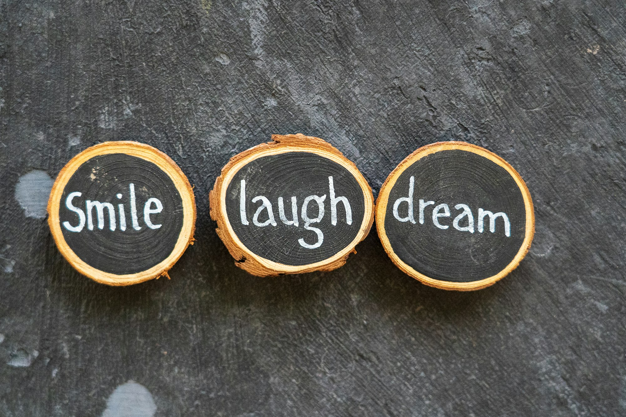 The words smile, laugh, dream on a magnetic poetry board.