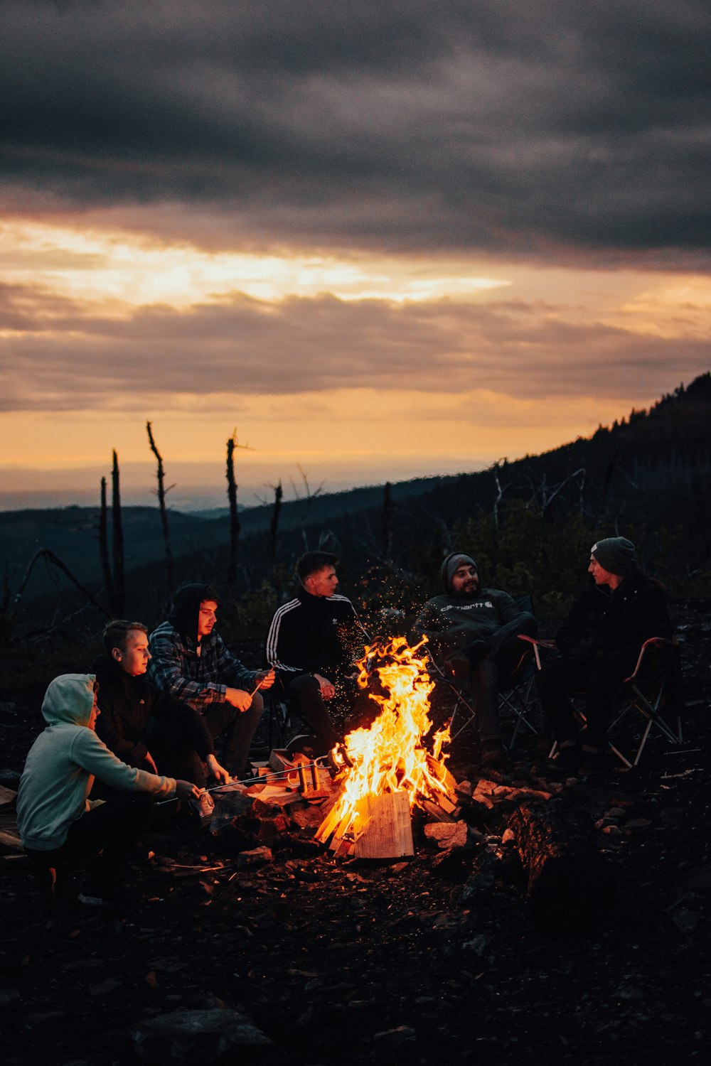 a group of people sitting around a campfire