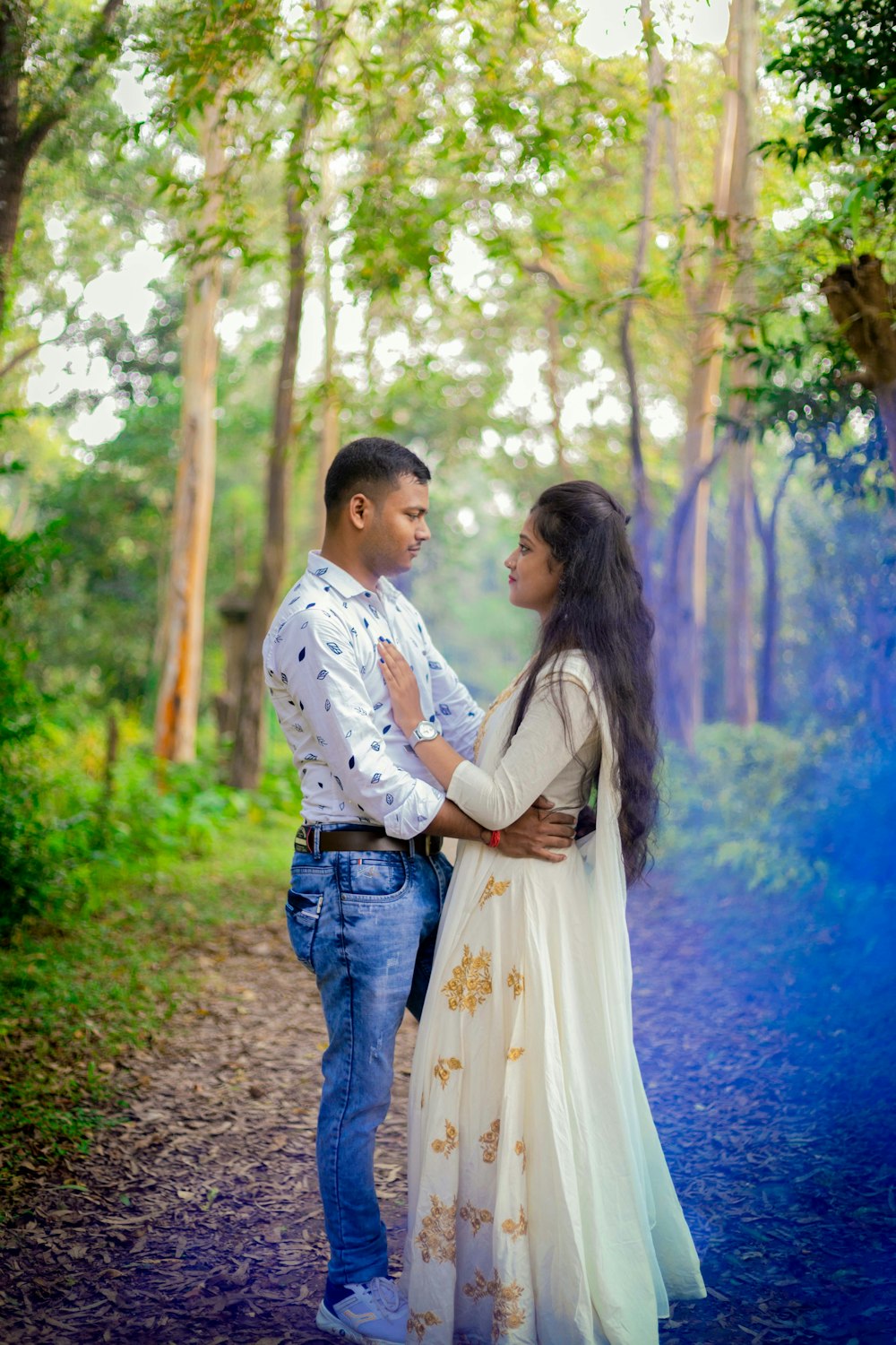 a man and a woman standing in the woods