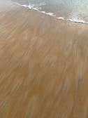 A gentle wave washing over sand, leaving natural patterns like subconscious symbols.