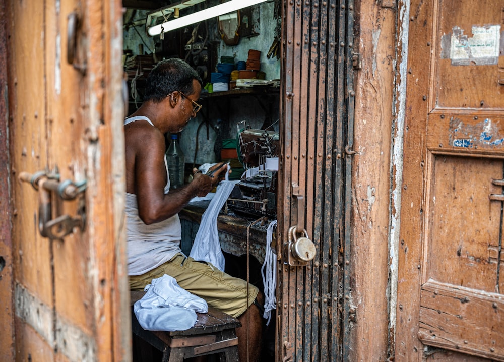 a man sitting on a chair working on a piece of paper