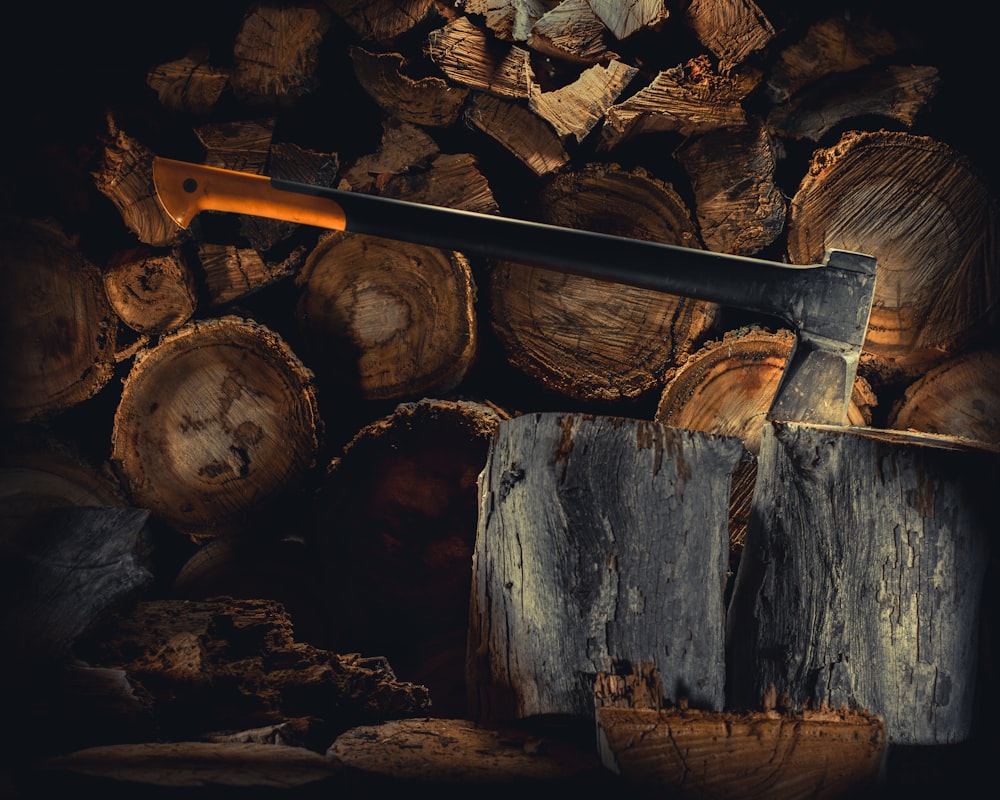 a large knife sitting on top of a pile of logs