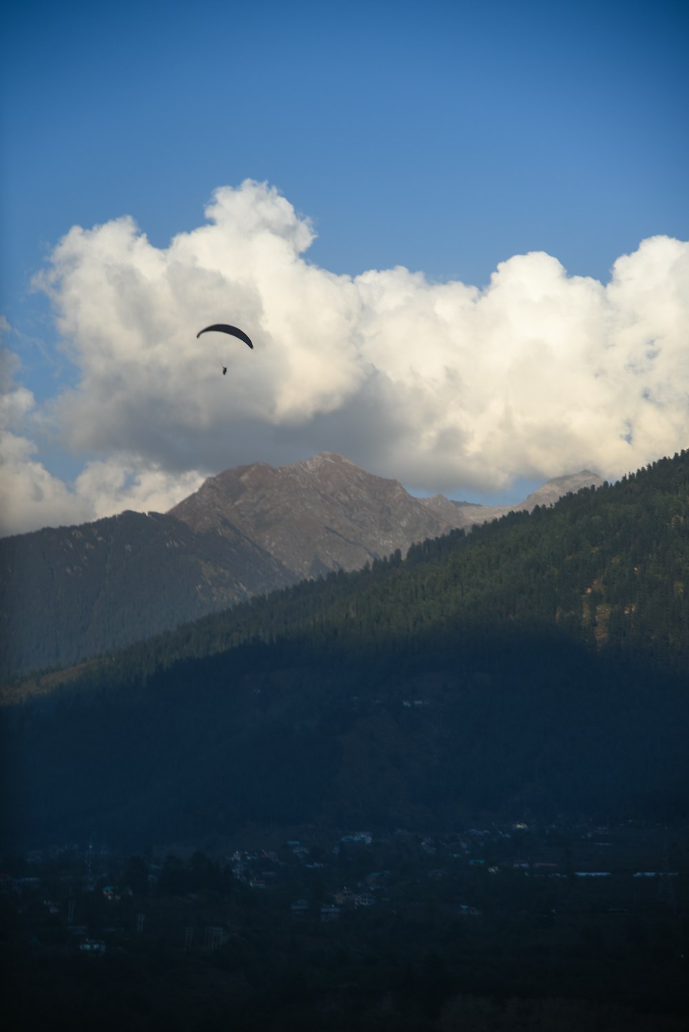 a paraglider is flying over a mountainous area