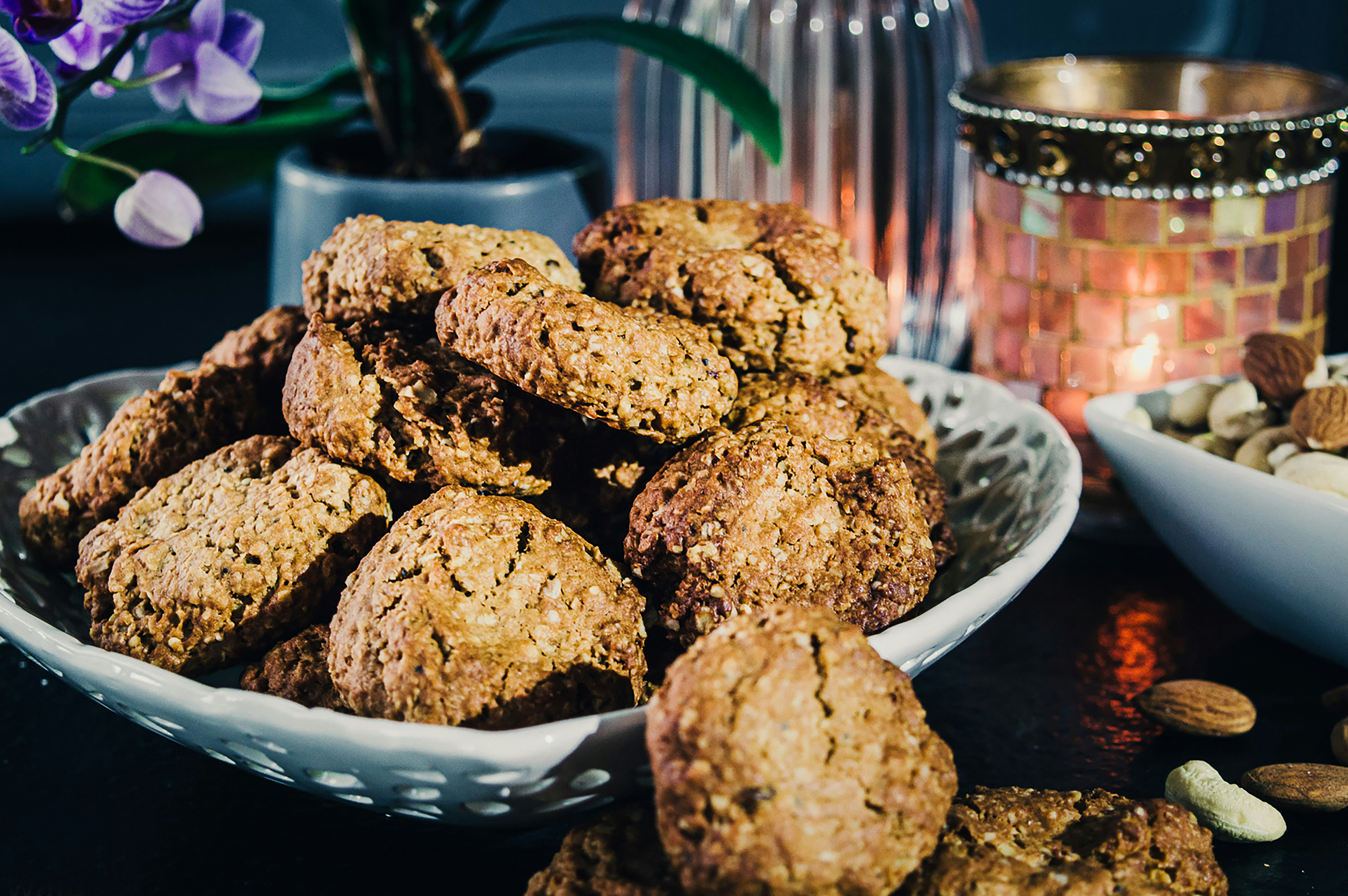 une assiette pleine de biscuits à côté d’un bol de noix