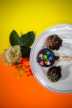 Close-up of elegant chocolate-dipped cake pops decorated with gold leaf accents.