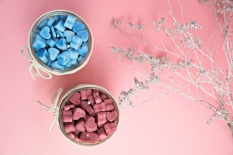 two small bowls of candy on a pink background