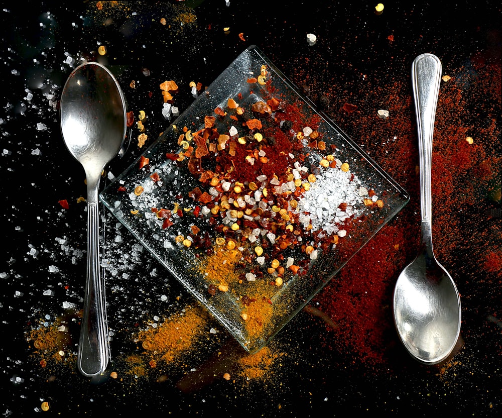 spoons and a glass dish filled with spices