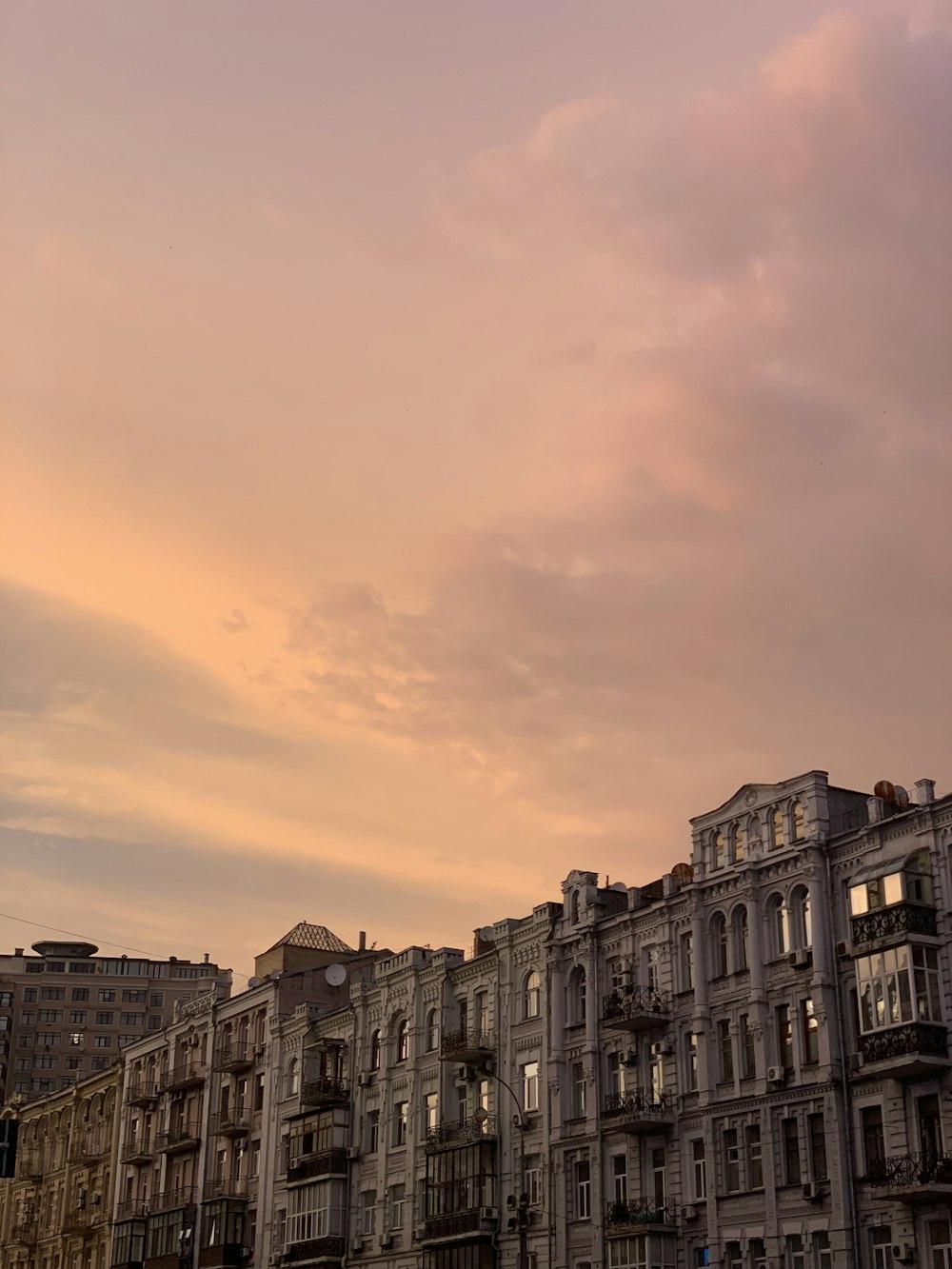 a row of buildings with a pink sky in the background