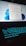 A laptop with a glowing backlit keyboard and a desktop screen displaying various icons and applications. The keyboard emits a blue-green light, creating a futuristic look. The desktop screen shows a start menu with pinned and recommended applications, set against a light blue background.