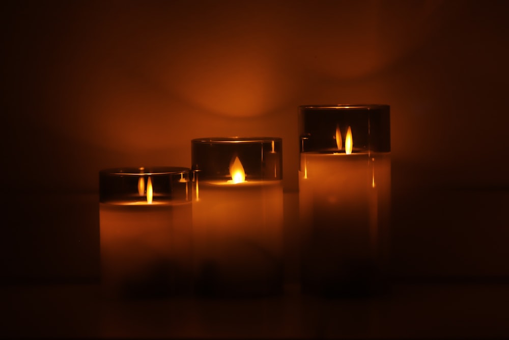 a group of three lit candles sitting next to each other