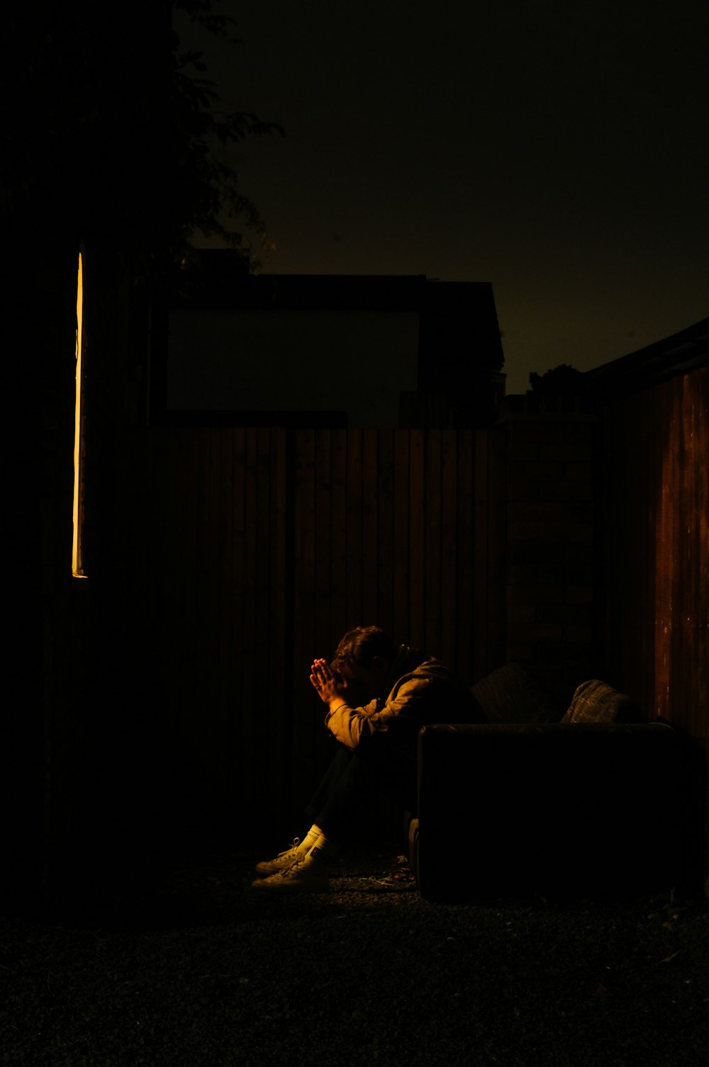 a person sitting on a couch in the dark