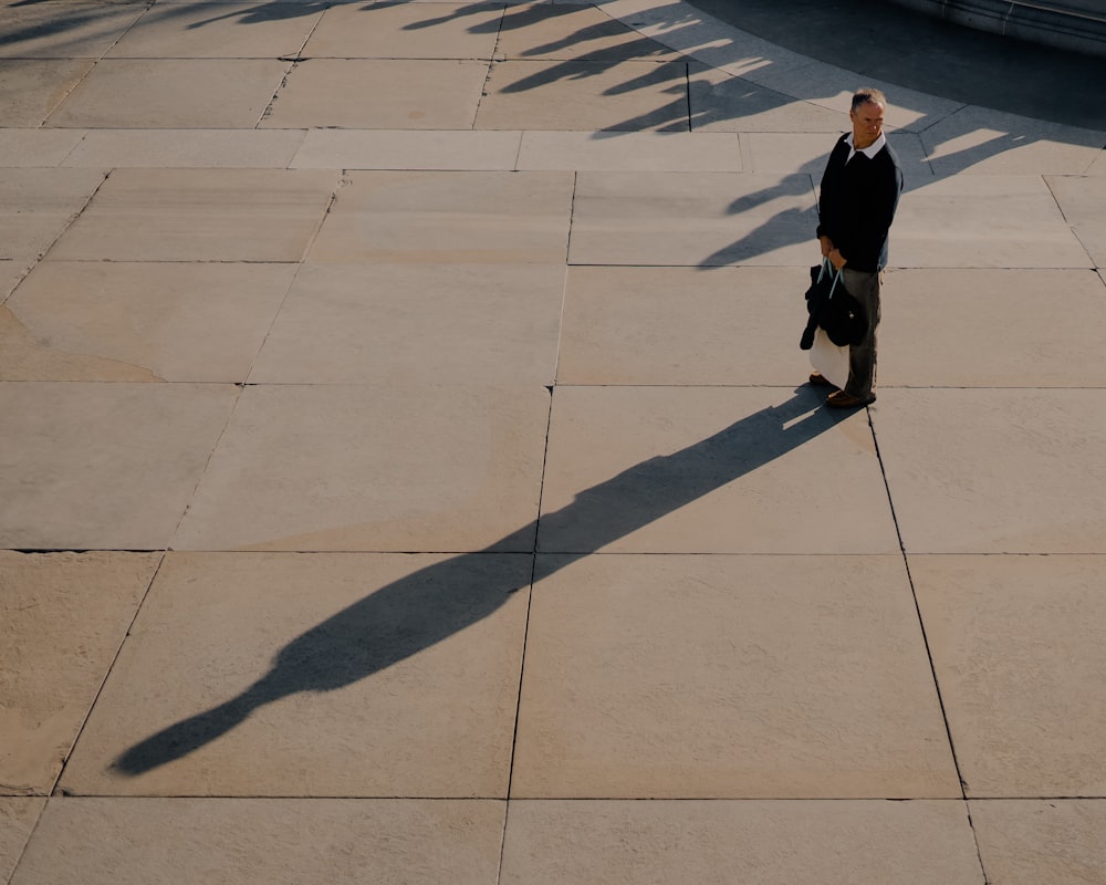 a man in a suit and tie walking down a sidewalk