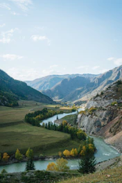 a river running through a valley surrounded by mountains