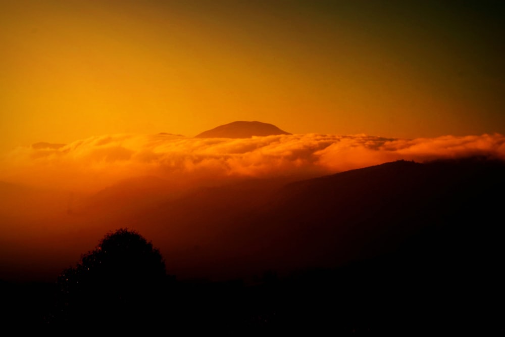 the sun is setting over a mountain range