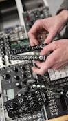 Close-up of hands assembling a high-fi prototype with electronic components.
