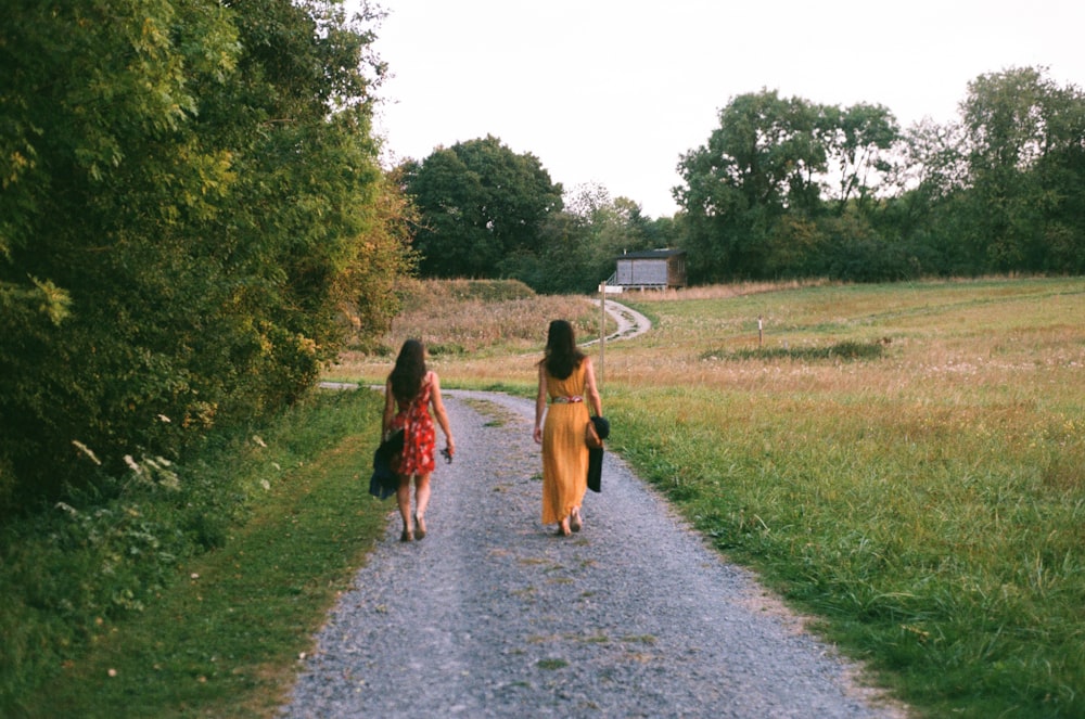 two women walking down a path in a field