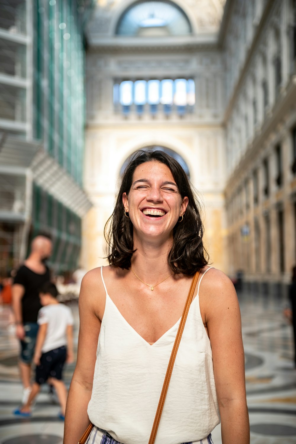 a woman smiles while standing in a building