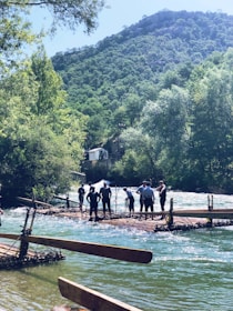 Group of people rafting on a river surrounded by lush green forest.