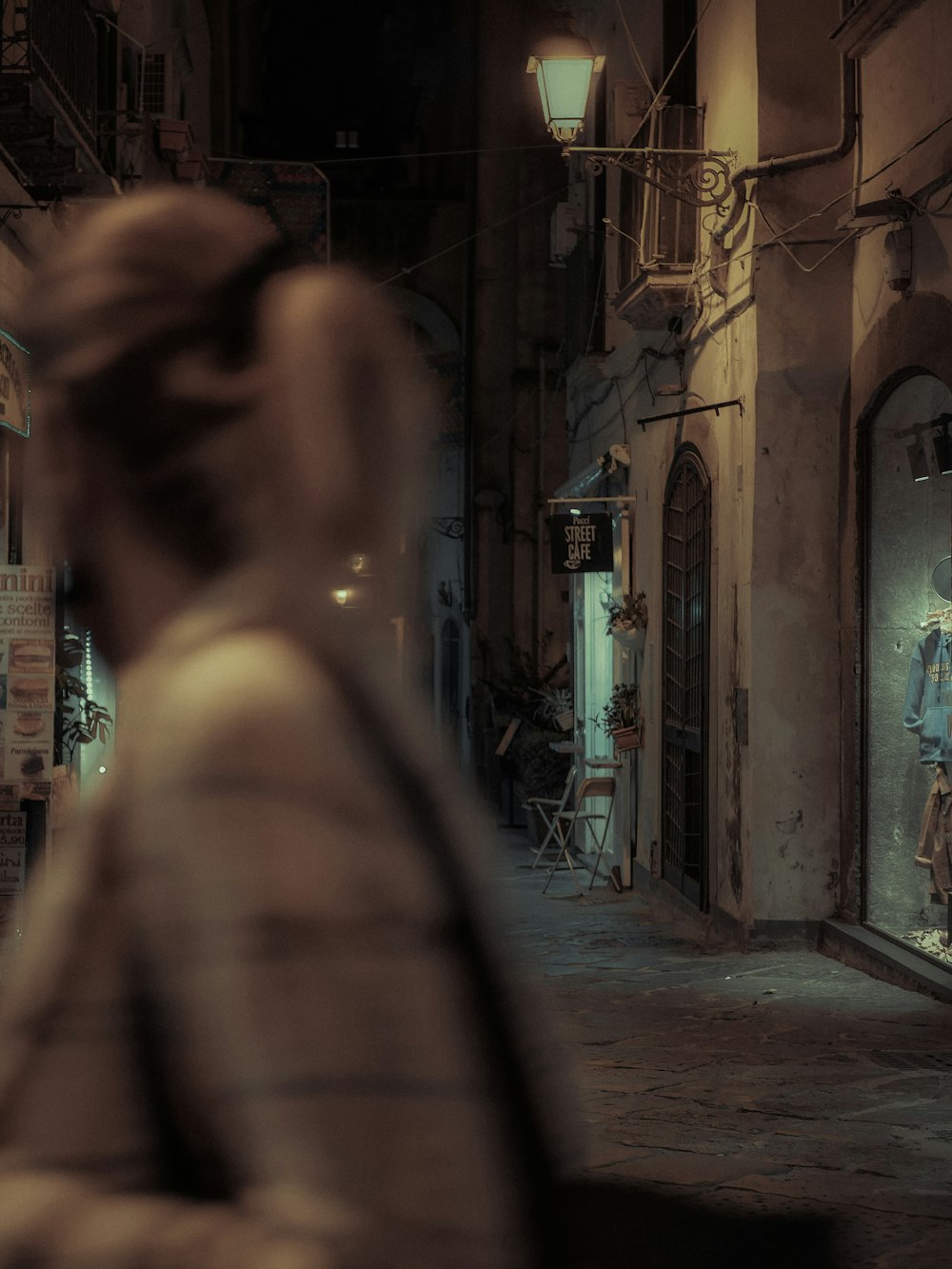 a woman walking down a street at night