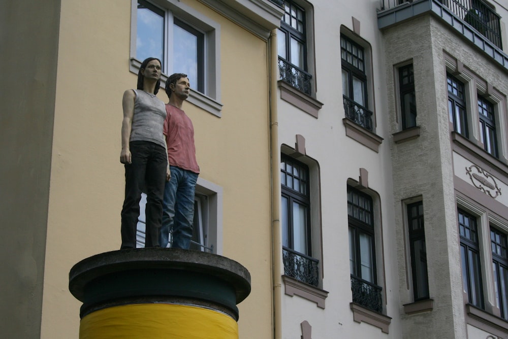 a couple of people standing on top of a statue