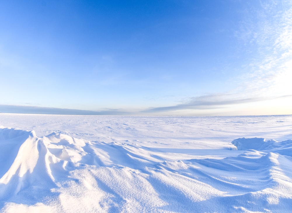 a snow covered landscape with a bright blue sky