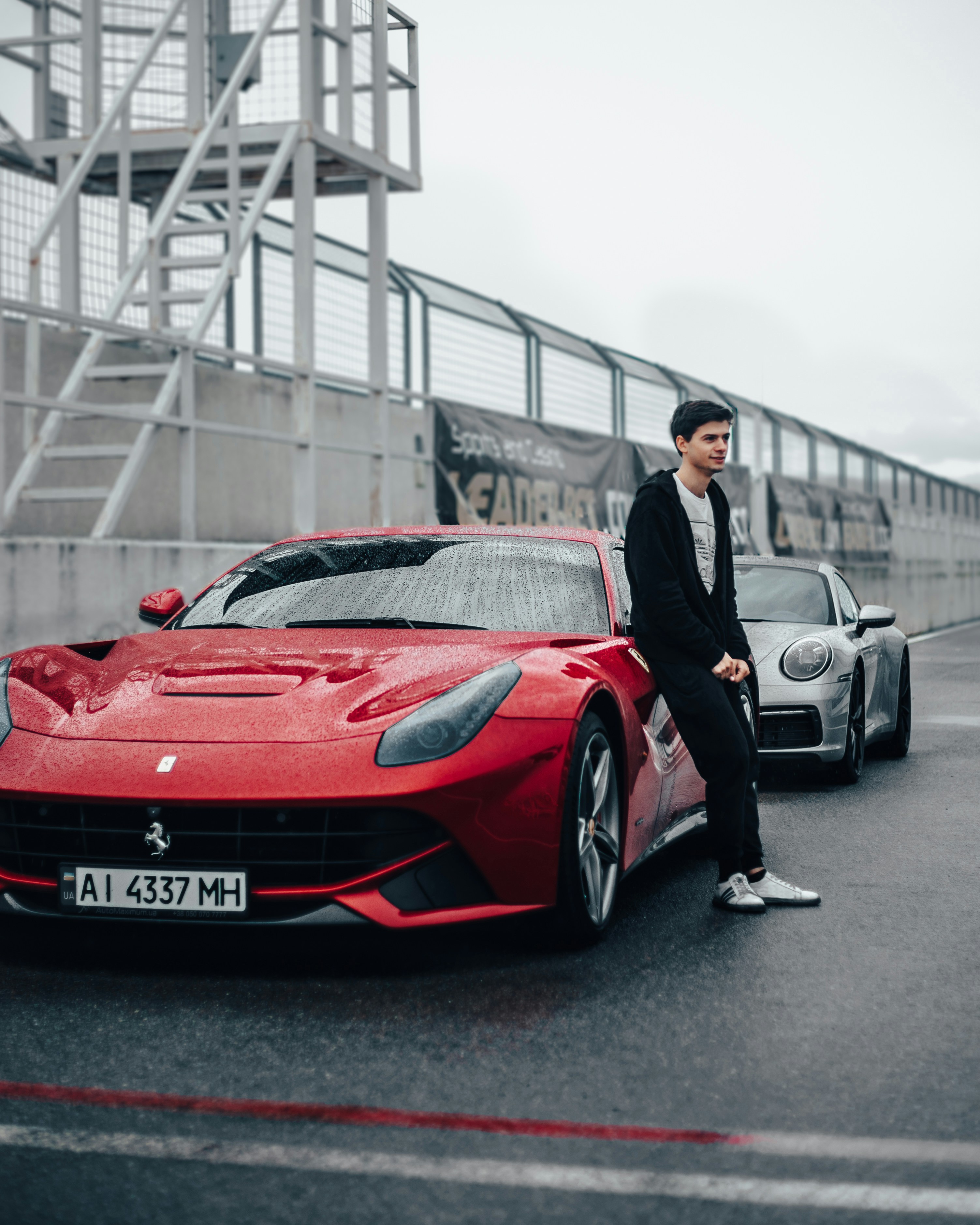 A man standing next to a red sports car photo – Free Gray Image on Unsplash