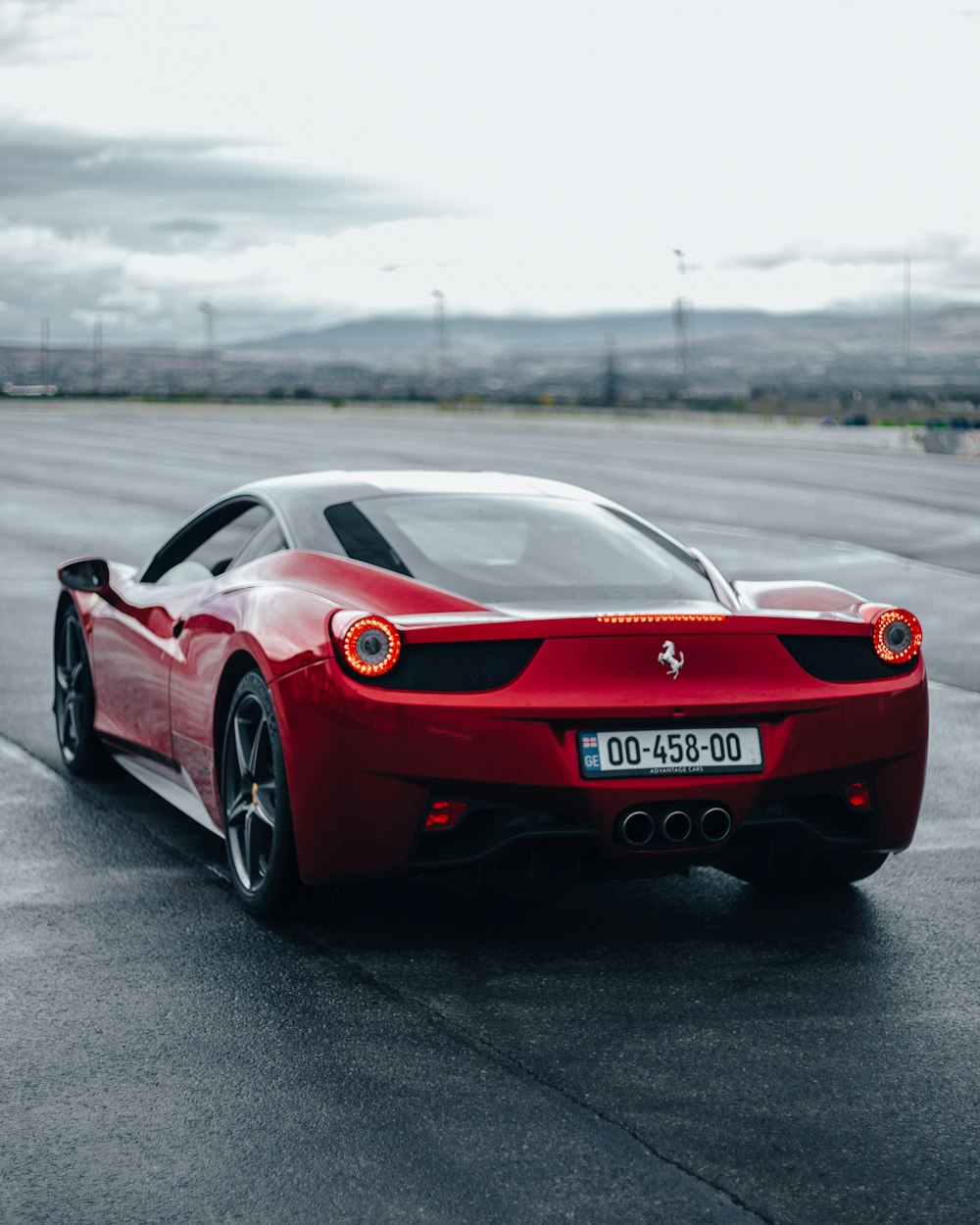 a red ferrari sports car driving down a road