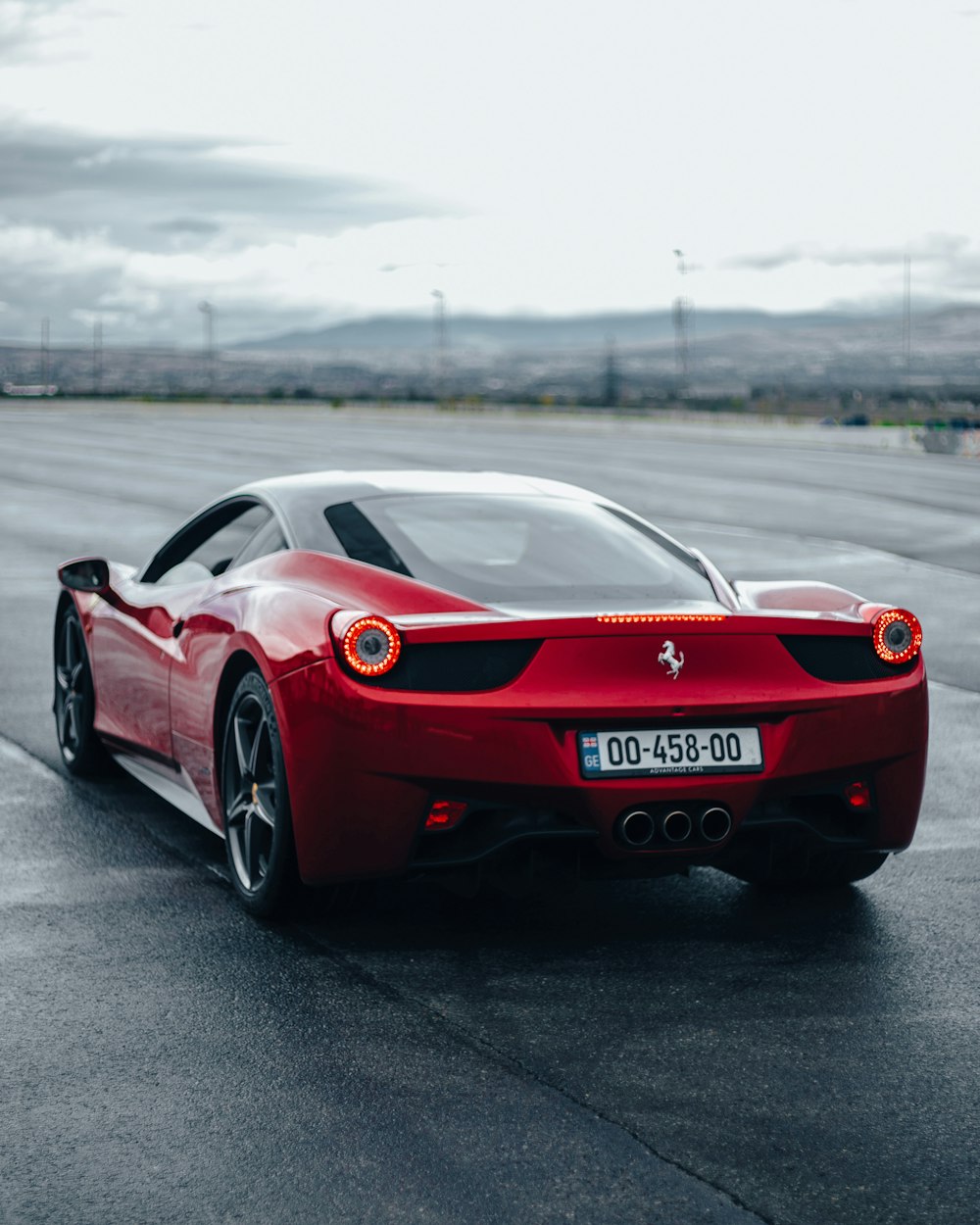 Un'auto sportiva Ferrari rossa che guida lungo una strada