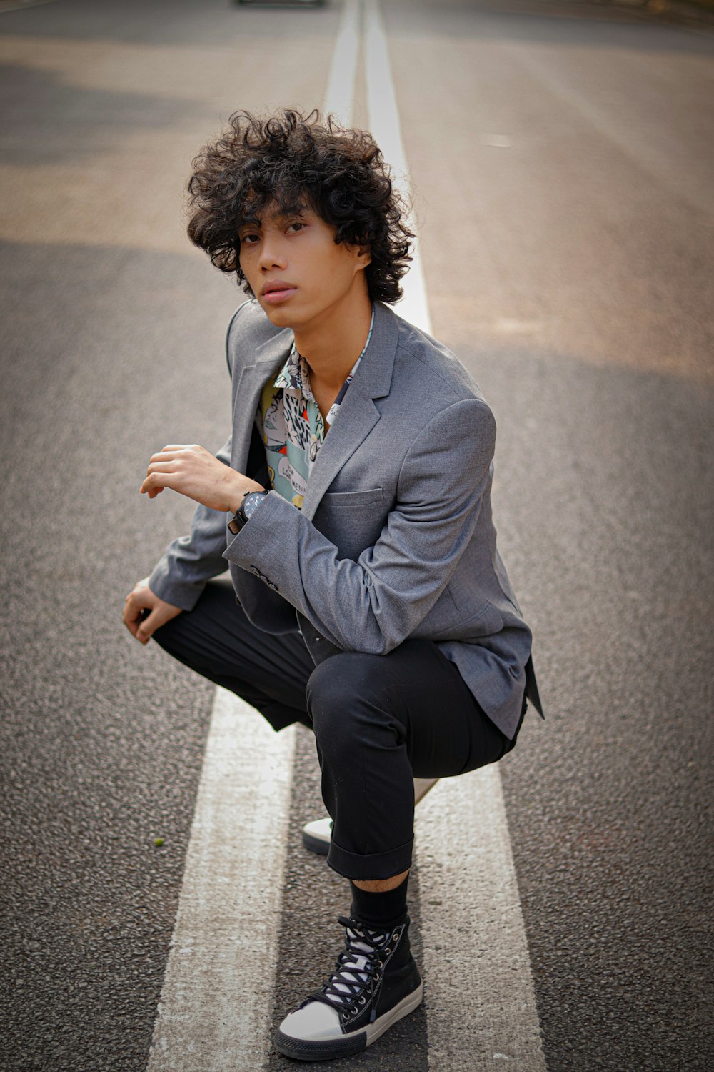 a man kneeling down on the side of a road