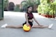 a woman sitting on the ground with a basketball