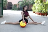 a woman sitting on the ground with a basketball