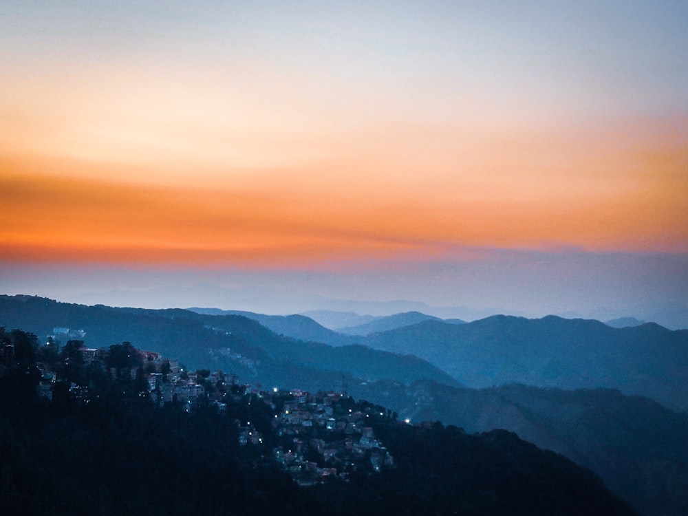 a view of a city in the distance with mountains in the background