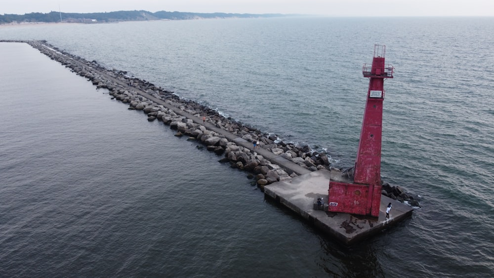 a red light tower sitting in the middle of a body of water