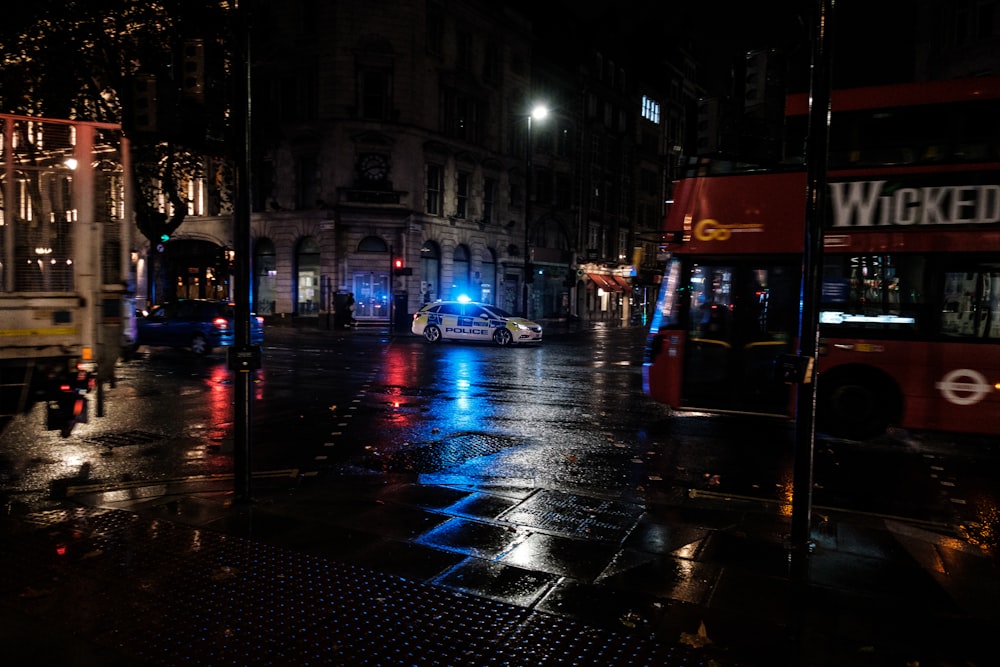 a city street at night with a double decker bus