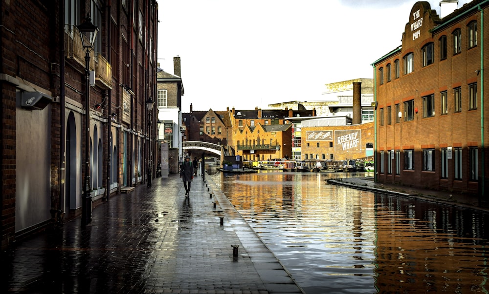 a wet city street with people walking on it