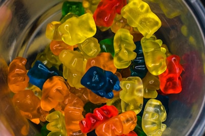 A close-up of colorful gummy bears arranged on a wooden table.