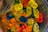 Close-up of colorful gummy worms twisting around each other on a bright background.